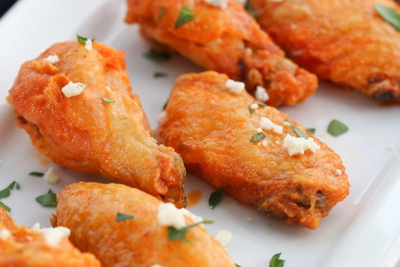 Adding the finishing touches to Crispy Baked Buffalo Chicken Wings