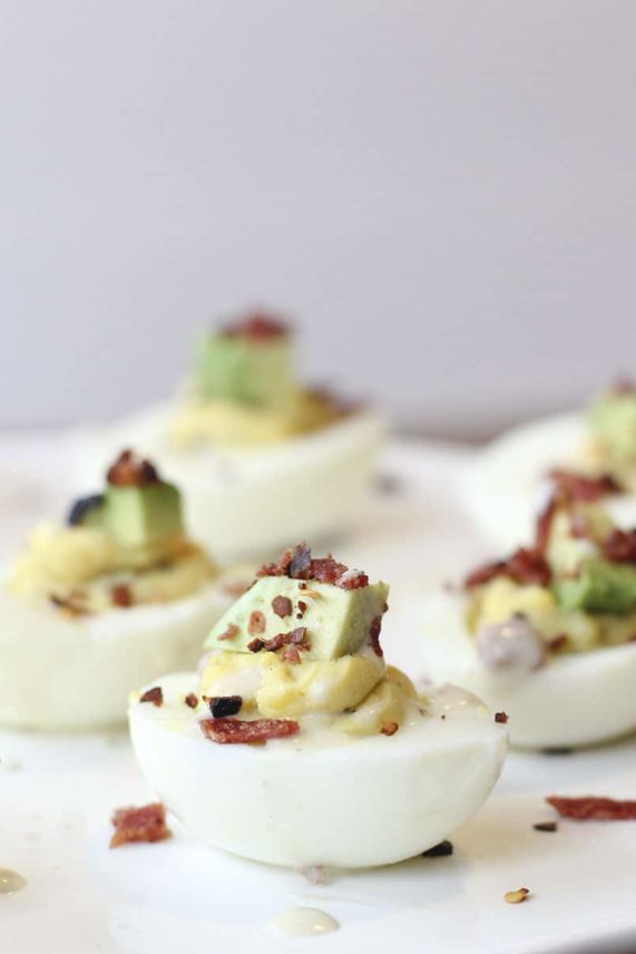 Adding finishing touches to Avocado Bacon Ranch Deviled Eggs